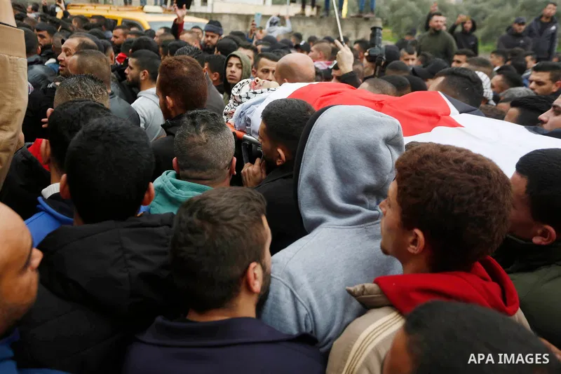 Mourners carry the body of Palestinian teenager Mohammed Abu Salah, 17, who was killed after Israeli forces entered the village of Silat al-Harithiya during his funeral in the West Bank city of Jenin, on February 14, 202...