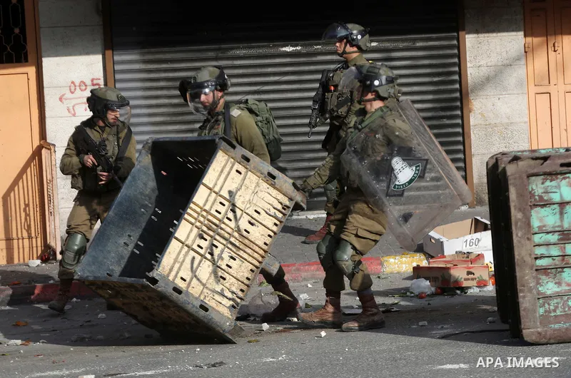 Israeli security forces take position during clashes with Palestinian protesters following the Friday prayers in the West Bank town of Hebron, February 18, 2022. Photo by Mamoun Wazwaz
