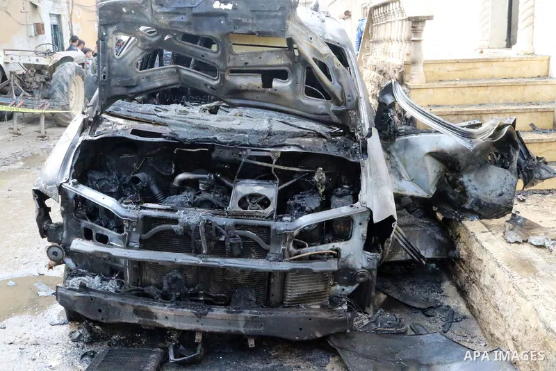 Security forces inspect the scene of an explosion that targeted the vehicle of and killed a member of the Syrian fighters in Syria's town of Azaz in northern countryside of Syria's Aleppo province near the border with Tu...