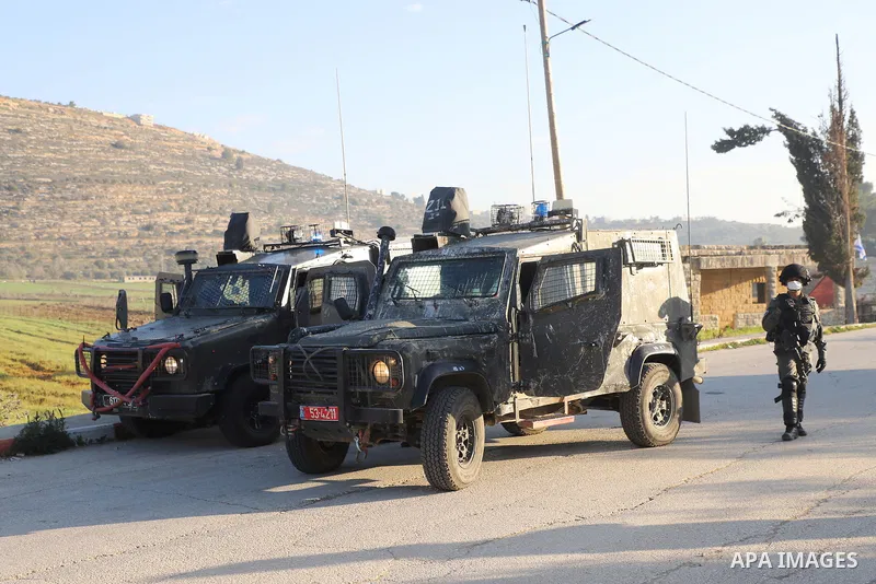 Palestinian students walk to their schools from the main road in al-Lubban al-Sharqiya village, south of Nablus city, in the West Bank on February 23, 2022. Dozens of rampaging Israeli settler fanatics today attacked the...