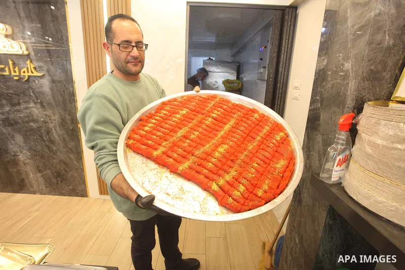 A Palestinian vendor sells Kunafa sweets at a store in Gaza city on Feb. 24, 2022. Kunafa is a traditional Arabic dessert made of cheese, flour, syrup, and added with nuts as ingredients. Photo by Youssef Abu Watfa