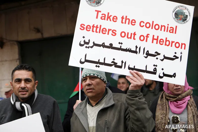 Protesters take part during an annual demonstration in memory of the 1994 Ibrahimi Mosque massacre, near a gate leading to Hebron's main al-Shuhada street, in the West Bank city of Hebron on Feb. 25, 2022. Photo by Mamou...