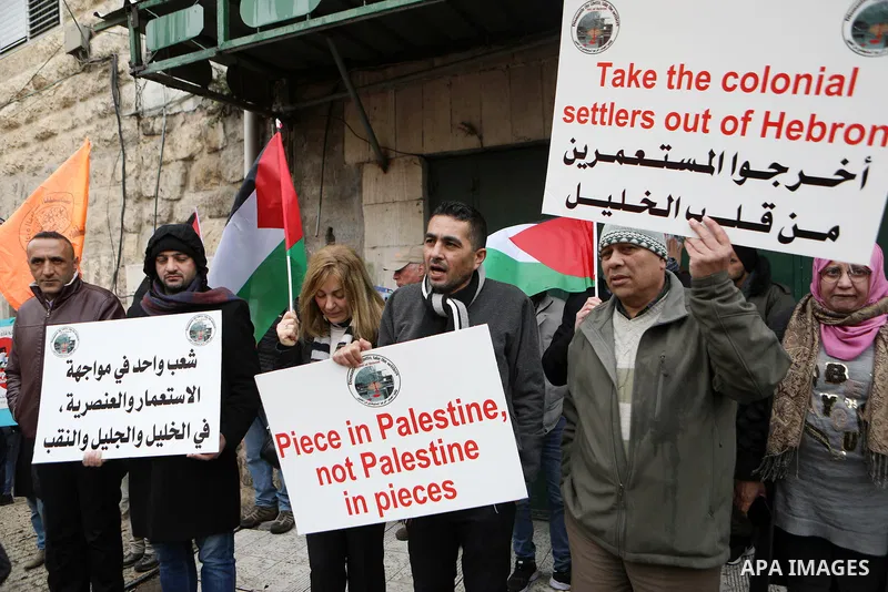 Protesters take part during an annual demonstration in memory of the 1994 Ibrahimi Mosque massacre, near a gate leading to Hebron's main al-Shuhada street, in the West Bank city of Hebron on Feb. 25, 2022. Photo by Mamou...