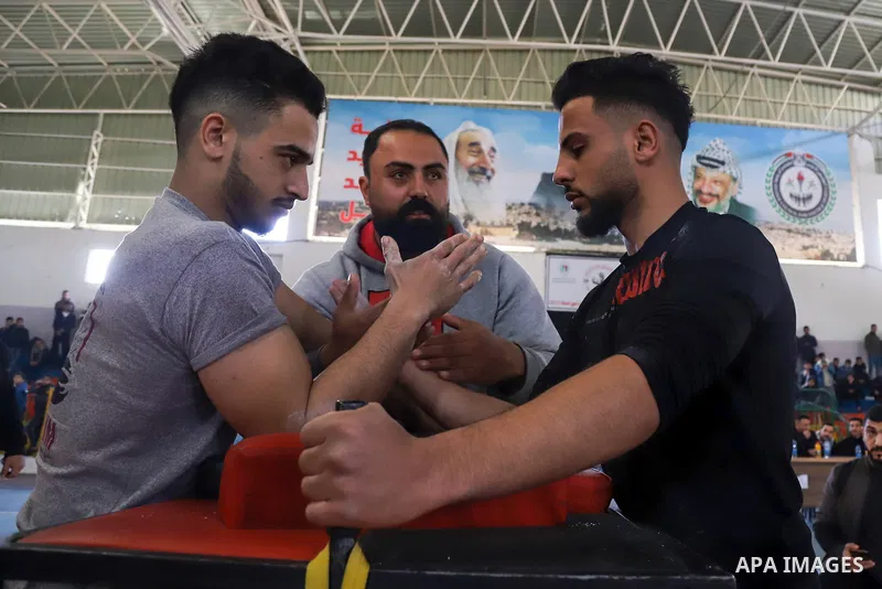 Palestinian youths compete in an arm-wrestling championship in Gaza City on February 25, 2022. Photo by Omar Ashtawy