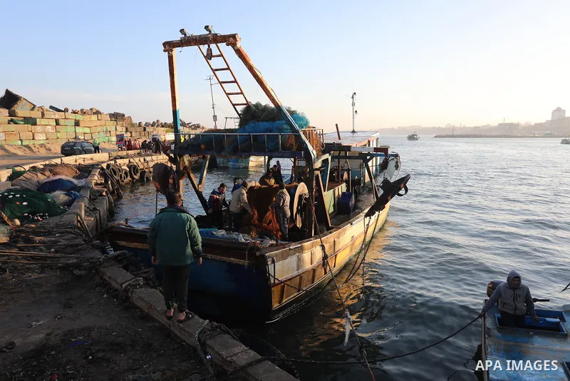 Palestinian fishermen work at Gaza City's main port, on February 27, 2022. The bad weather and snow that hit Palestine led to the disruption of fishermen's work at sea in the past days. Photo by Ashraf Amra