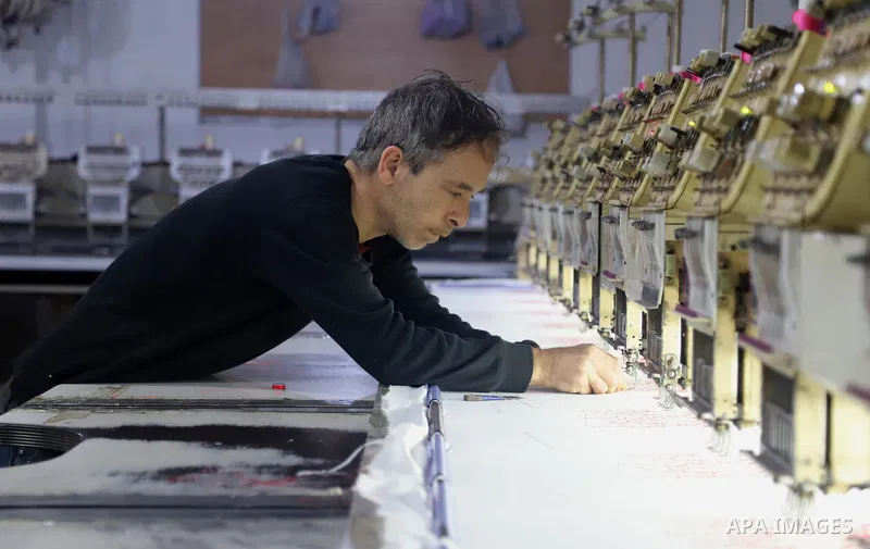 Palestinians work at heritage embroidery factory on February 28, 2022. "Year by year there is a greater demand for the Palestinian dress on public and private occasions. Women are proud to wear them," Riad Al-Shorafa sai...