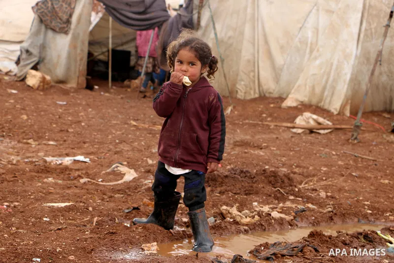 Syrian refugees play near their tents during a winter season, outside the Syrian city of Azaz on Syria's northern border with Turkey, on March 18, 2022. Photo by Samir Abed.