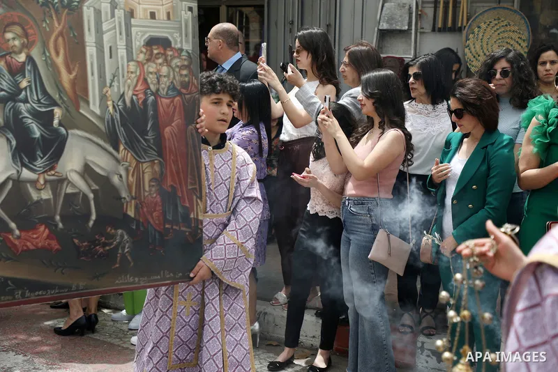 Christians attend Palm Sunday in the West Bank city of Ramallah on April 17, 2022. Palm Sunday commemorates the day the Gospel says Jesus rode into Jerusalem on a donkey and was hailed by the people, only to be crucified...