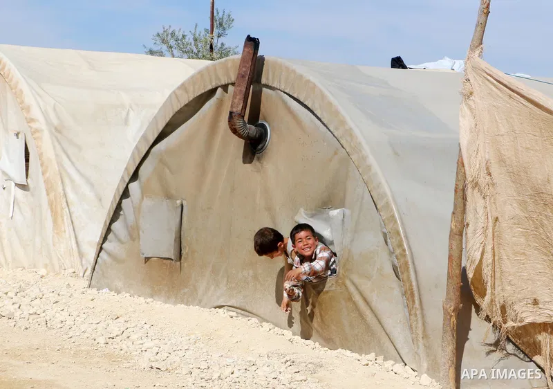 Syrian refugees play near their tents during the Muslims holy month of Ramadan, at Awtad camp north of Azaz on Syria's northern border with Turkey, on April 19, 2022. Photo by Samir Abed