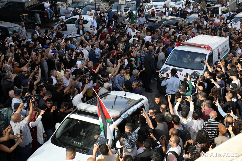 Colleagues and friends react as the Palestinian flag-draped body of veteran Al-Jazeera journalist Shireen Abu Akleh is brought to the news channel's office in the West Bank city of Ramallah, on May 11, 2022. - Al-Jazeera...