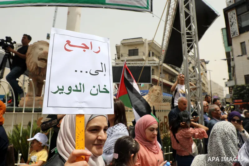 Palestinians wave national flags as they march in a rally marking the 74th anniversary of the "Nakba" or "catastrophe", in the West Bank city of Ramallah, on May 15, 2022. Each year Palestinians commemorate the "Nakba" o...