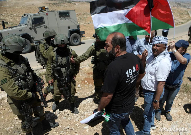 Palestinian activists scuffle with Israeli soldiers during a protest after Israeli top court paved way for razing eight Palestinian hamlets, in Masafer Yatta, south of Hebron, in the West Bank, on May 20, 2022. Photo by...