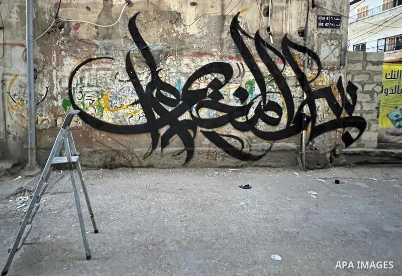 Palestinian artist Bilal Khaled draws on a wall a graffiti mural "In the name of the camp, I did not die and ask Jenin", in Burj al-Barajneh refugee camp, a Palestinian refugee camp in Beirut on June 10, 2022. Photo by N...