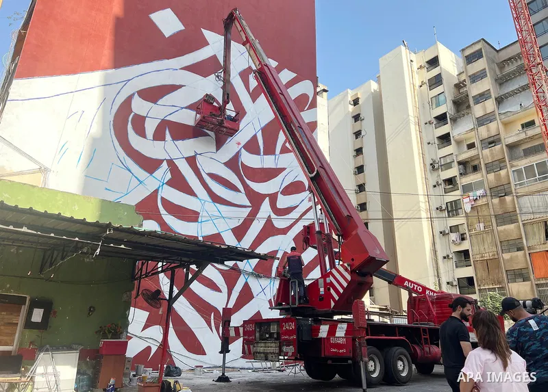 Palestinian artist Bilal Khaled draws on a wall a graffiti mural in Beirut on June 19, 2022. Photo by Nidal Al-Wahidi