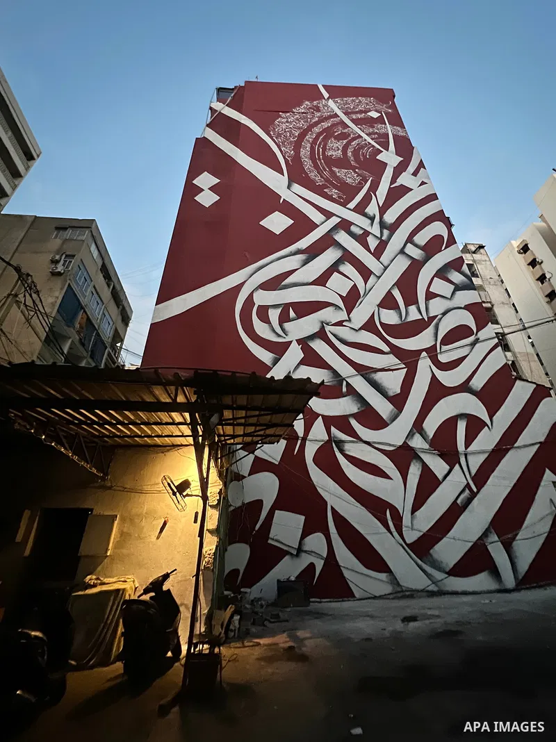 Palestinian artist Bilal Khaled draws on a wall a graffiti mural in Beirut on June 19, 2022. Photo by Nidal Al-Wahidi