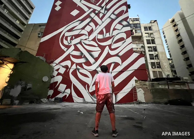 Palestinian artist Bilal Khaled draws on a wall a graffiti mural in Beirut on June 19, 2022. Photo by Nidal Al-Wahidi