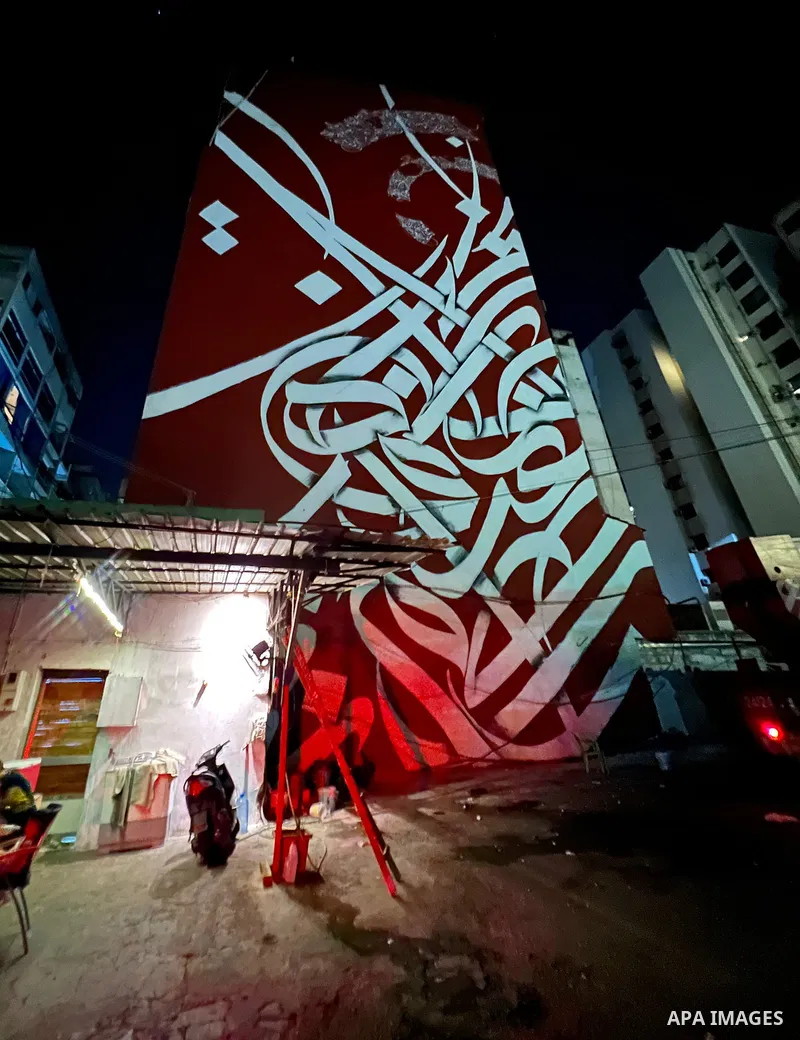Palestinian artist Bilal Khaled draws on a wall a graffiti mural in Beirut on June 19, 2022. Photo by Nidal Al-Wahidi