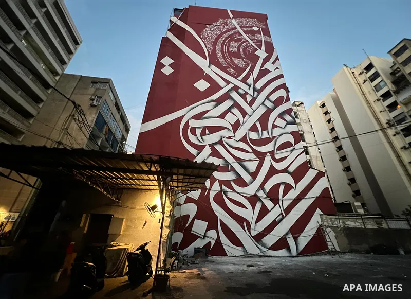 Palestinian artist Bilal Khaled draws on a wall a graffiti mural in Beirut on June 19, 2022. Photo by Nidal Al-Wahidi