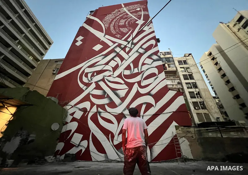Palestinian artist Bilal Khaled draws on a wall a graffiti mural in Beirut on June 19, 2022. Photo by Nidal Al-Wahidi