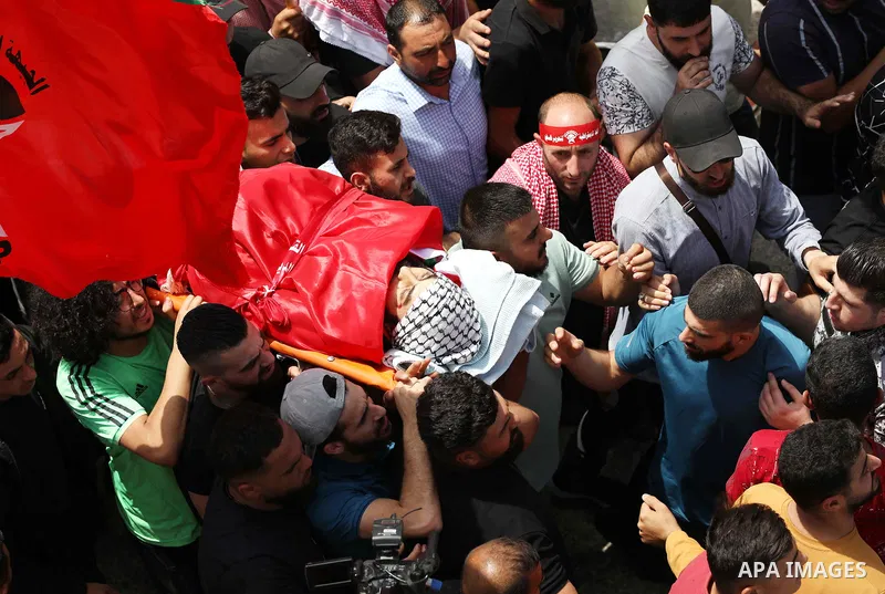 Mourners attend the funeral of Palestinian Ali Harb, who was killed by an Israeli settler in the northern West Bank village of Iskaka, on June 22, 2022. An Israeli settler stabbed a Palestinian to death in the West Bank...