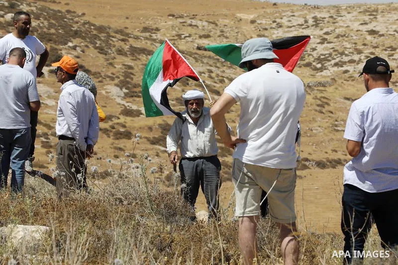 Palestinians scuffle with Israeli forces as settlers try to enter the lands of Palestinian farmers, in the Umm al-Rakhim area, near the town of Yatta, south of Hebron city in the West Bank on June 29, 2022. Photo by WAFA