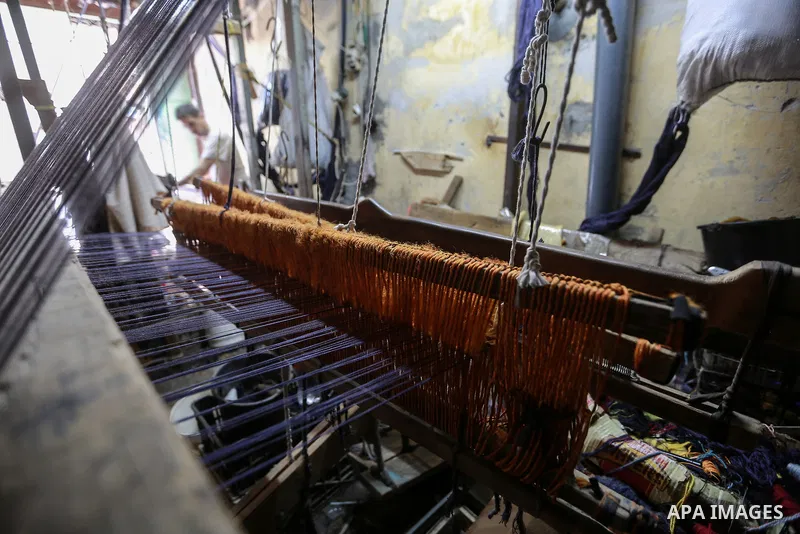 A Palestinian worker, Hanafi Al-Sawaf weaves carpets in a workshop in Gaza city on July 19, 2022. Weaving sheep's wool into traditional carpets is one oldest professions, it takes skill, patience and steady hand. Photo b...