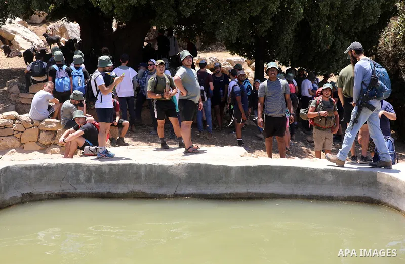 Israeli settlers gather around a water spring in the village of Ein Qinya, west of Ramallah in the West Bank, under the protection of the Israeli army, on July 19, 2022. Photo by Wajed Nobani