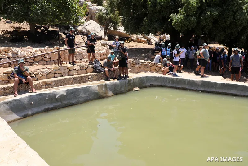 Israeli settlers gather around a water spring in the village of Ein Qinya, west of Ramallah in the West Bank, under the protection of the Israeli army, on July 19, 2022. Photo by Wajed Nobani