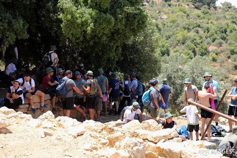 Israeli settlers gather around a water spring in the village of Ein Qinya, west of Ramallah in the West Bank, under the protection of the Israeli army, on July 19, 2022. Photo by Wajed Nobani
