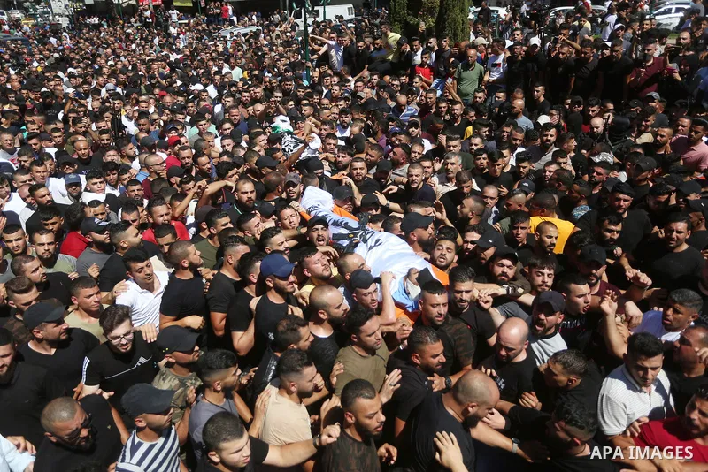 Mourners carry the bodies of two Palestinians who were killed by Israeli forces, during their funeral, in the West Bank city of Nablus on July 24, 2022. Two Palestinians were shot dead last night and ten others wounded,...