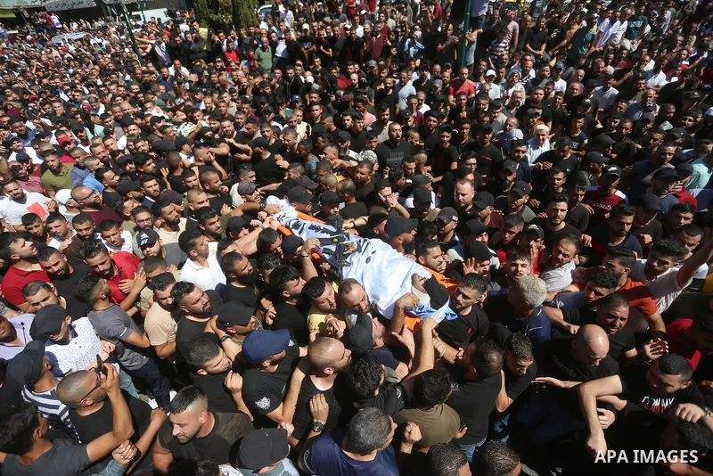 Mourners carry the bodies of two Palestinians who were killed by Israeli forces, during their funeral, in the West Bank city of Nablus on July 24, 2022. Two Palestinians were shot dead last night and ten others wounded,...