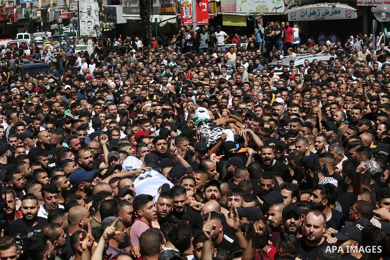 Mourners carry the bodies of two Palestinians who were killed by Israeli forces, during their funeral, in the West Bank city of Nablus on July 24, 2022. Two Palestinians were shot dead last night and ten others wounded,...
