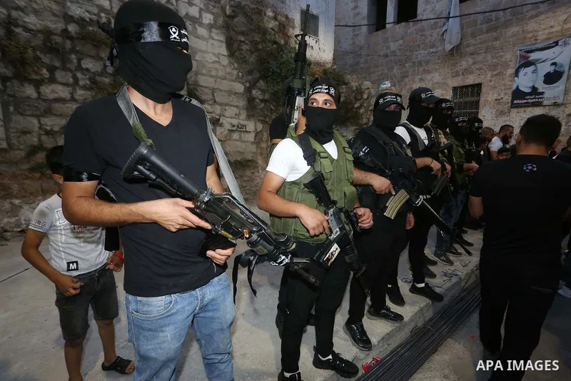 Palestinian militants from the Al-Aqsa Martyrs Brigades, the military wing of the Fatah movement, participate in the ceremony for the prisoner Abd al-Salam Shabaro, upon his release from Israeli jails, in the West Bank c...
