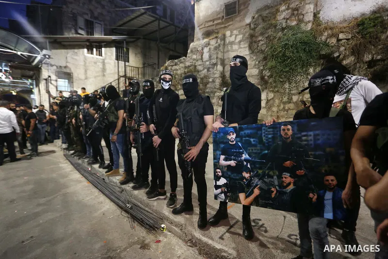 Palestinian militants from the Al-Aqsa Martyrs Brigades, the military wing of the Fatah movement, participate in the ceremony for the prisoner Abd al-Salam Shabaro, upon his release from Israeli jails, in the West Bank c...