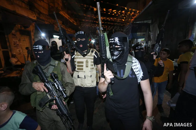Palestinian militants from the Al-Aqsa Martyrs Brigades, the military wing of the Fatah movement, participate in the ceremony for the prisoner Abd al-Salam Shabaro, upon his release from Israeli jails, in the West Bank c...
