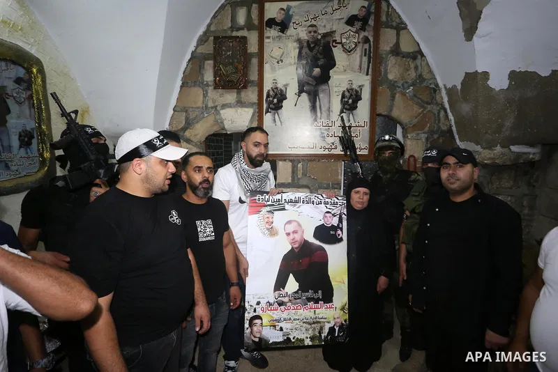 Palestinian militants from the Al-Aqsa Martyrs Brigades, the military wing of the Fatah movement, participate in the ceremony for the prisoner Abd al-Salam Shabaro, upon his release from Israeli jails, in the West Bank c...