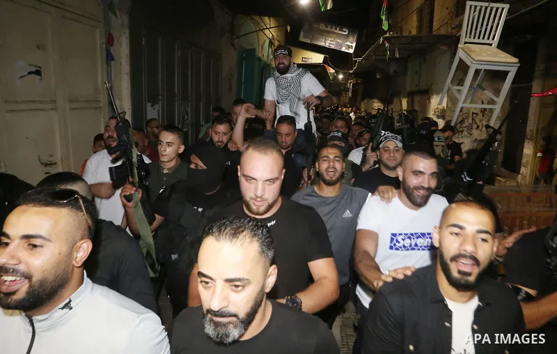 Palestinian militants from the Al-Aqsa Martyrs Brigades, the military wing of the Fatah movement, participate in the ceremony for the prisoner Abd al-Salam Shabaro, upon his release from Israeli jails, in the West Bank c...