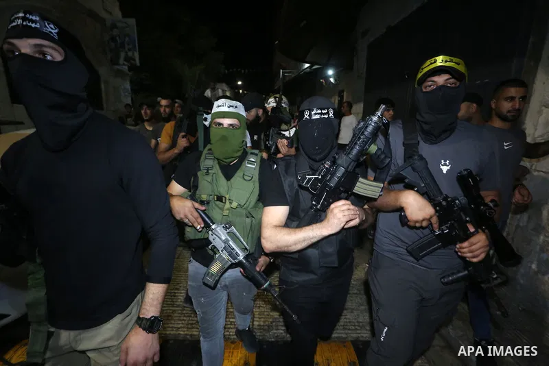 Palestinian militants from the Al-Aqsa Martyrs Brigades, the military wing of the Fatah movement, participate in the ceremony for the prisoner Abd al-Salam Shabaro, upon his release from Israeli jails, in the West Bank c...