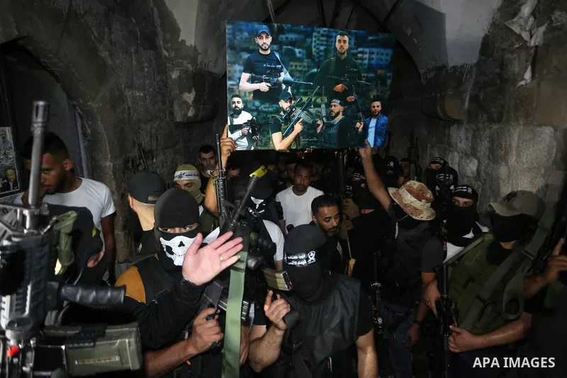 Palestinian militants from the Al-Aqsa Martyrs Brigades, the military wing of the Fatah movement, participate in the ceremony for the prisoner Abd al-Salam Shabaro, upon his release from Israeli jails, in the West Bank c...