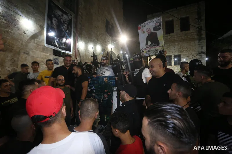 Palestinian militants from the Al-Aqsa Martyrs Brigades, the military wing of the Fatah movement, participate in the ceremony for the prisoner Abd al-Salam Shabaro, upon his release from Israeli jails, in the West Bank c...
