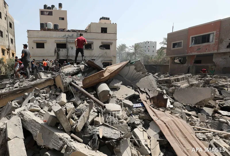 Palestinians inspect the rubble of a building following an Israeli air strike in Gaza City on August 6, 2022. Israel attacked the besieged Gaza Strip with warplanes on Friday, killing at least 11 people including a comma...