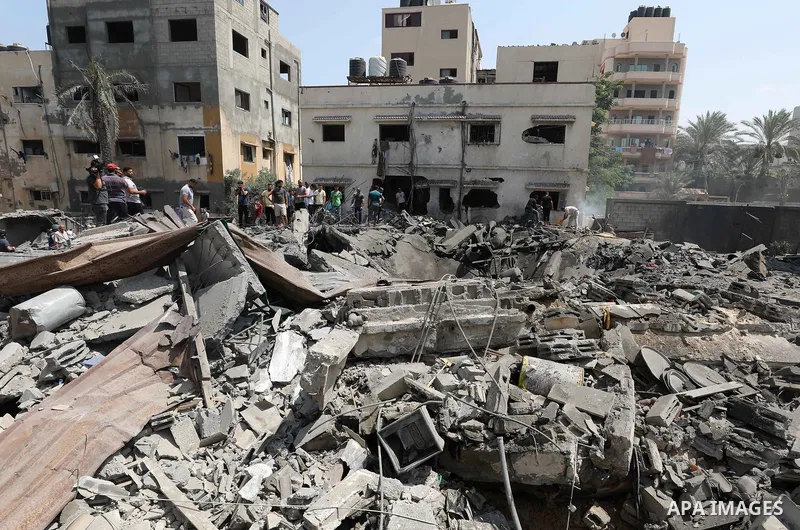 Palestinians inspect the rubble of a building following an Israeli air strike in Gaza City on August 6, 2022. Israel attacked the besieged Gaza Strip with warplanes on Friday, killing at least 11 people including a comma...