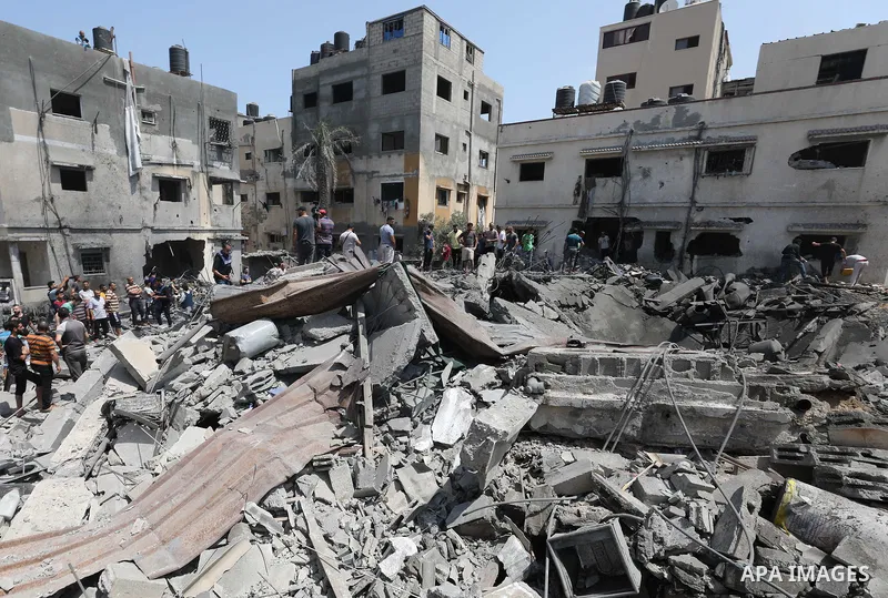 Palestinians inspect the rubble of a building following an Israeli air strike in Gaza City on August 6, 2022. Israel attacked the besieged Gaza Strip with warplanes on Friday, killing at least 11 people including a comma...