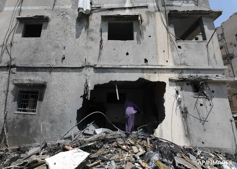 Palestinians inspect the rubble of a building following an Israeli air strike in Gaza City on August 6, 2022. Israel attacked the besieged Gaza Strip with warplanes on Friday, killing at least 11 people including a comma...
