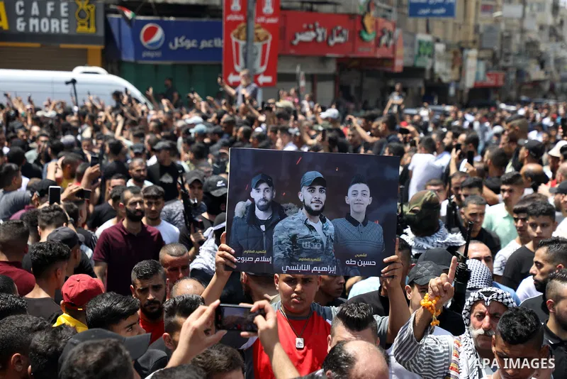 Mourners attend the funeral of Palestinian commander of the Al-Aqsa Martyrs' Brigade Ibrahim al-Nabulsi along with two of his comrades, who was killed in an Israeli raid, in the West Bank city of Nablus on August 9, 2022...