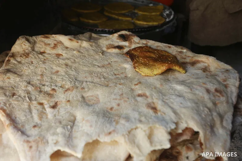 Palestinian woman Fatima Hammad, 57 prepares the traditional bread "Taboon", in town of Jama'in, south of the West Bank city of Nablus, on August 17, 2022. Taboon bread is Levantine flatbread baked in a taboon or tannur...