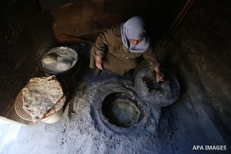 Palestinian woman Fatima Hammad, 57 prepares the traditional bread "Taboon", in town of Jama'in, south of the West Bank city of Nablus, on August 17, 2022. Taboon bread is Levantine flatbread baked in a taboon or tannur...
