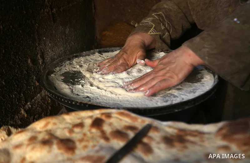 Palestinian woman Fatima Hammad, 57 prepares the traditional bread "Taboon", in town of Jama'in, south of the West Bank city of Nablus, on August 17, 2022. Taboon bread is Levantine flatbread baked in a taboon or tannur...