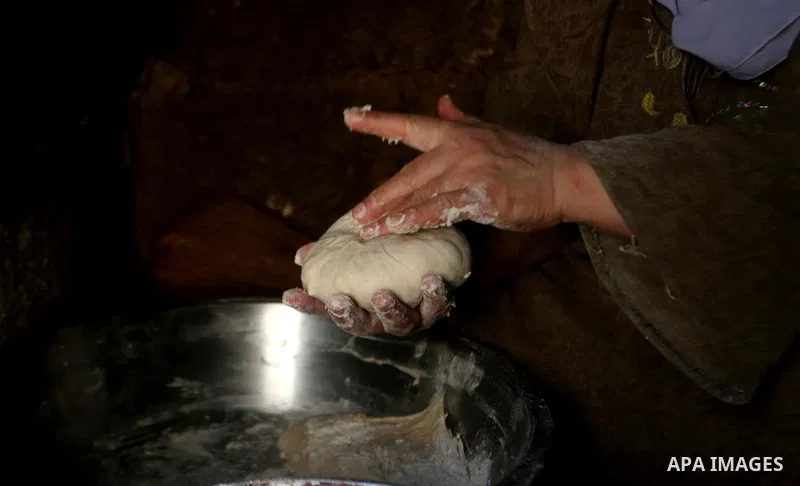 Palestinian woman Fatima Hammad, 57 prepares the traditional bread "Taboon", in town of Jama'in, south of the West Bank city of Nablus, on August 17, 2022. Taboon bread is Levantine flatbread baked in a taboon or tannur...