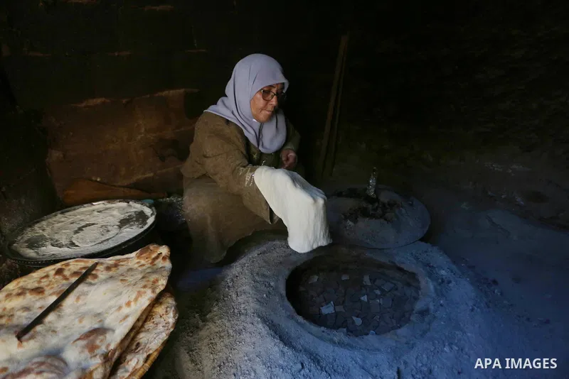 Palestinian woman Fatima Hammad, 57 prepares the traditional bread "Taboon", in town of Jama'in, south of the West Bank city of Nablus, on August 17, 2022. Taboon bread is Levantine flatbread baked in a taboon or tannur...